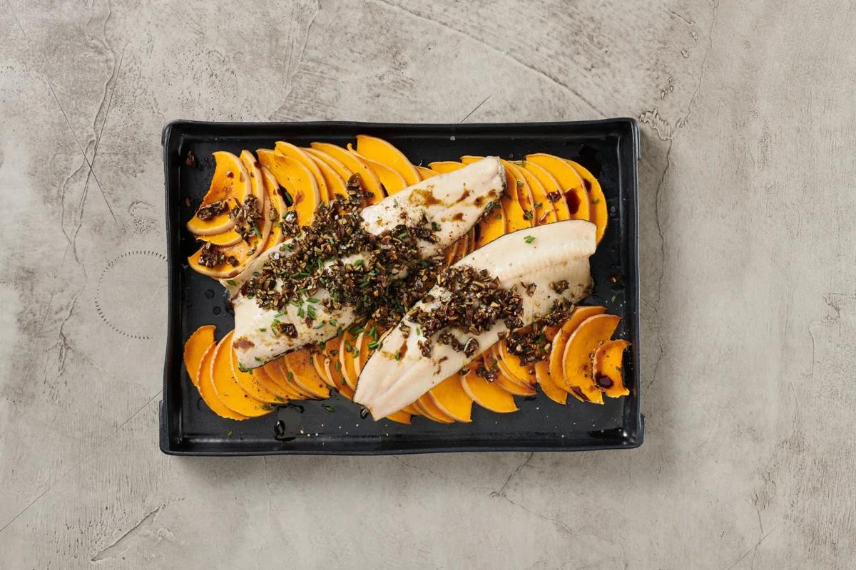 Fisch auf Kürbis. Das fertige Gericht schön angerichtet und fotografiert aus Vogelperspektive (Food Fotografie). Serviervorschlag, Original Tiptopf Rezept, aus dem bekanntesten Kochbuch der Schweiz